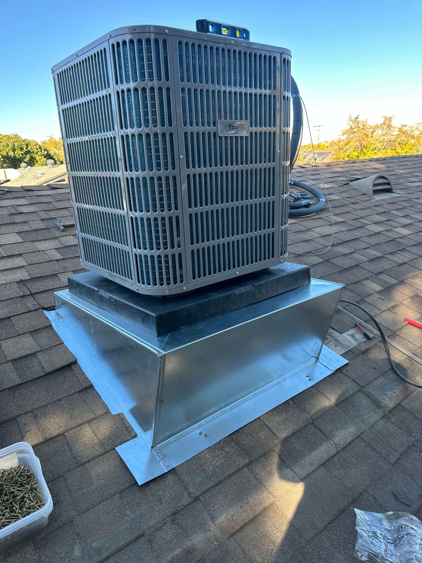 AC Pro residential condenser installed on a shingle roof platform