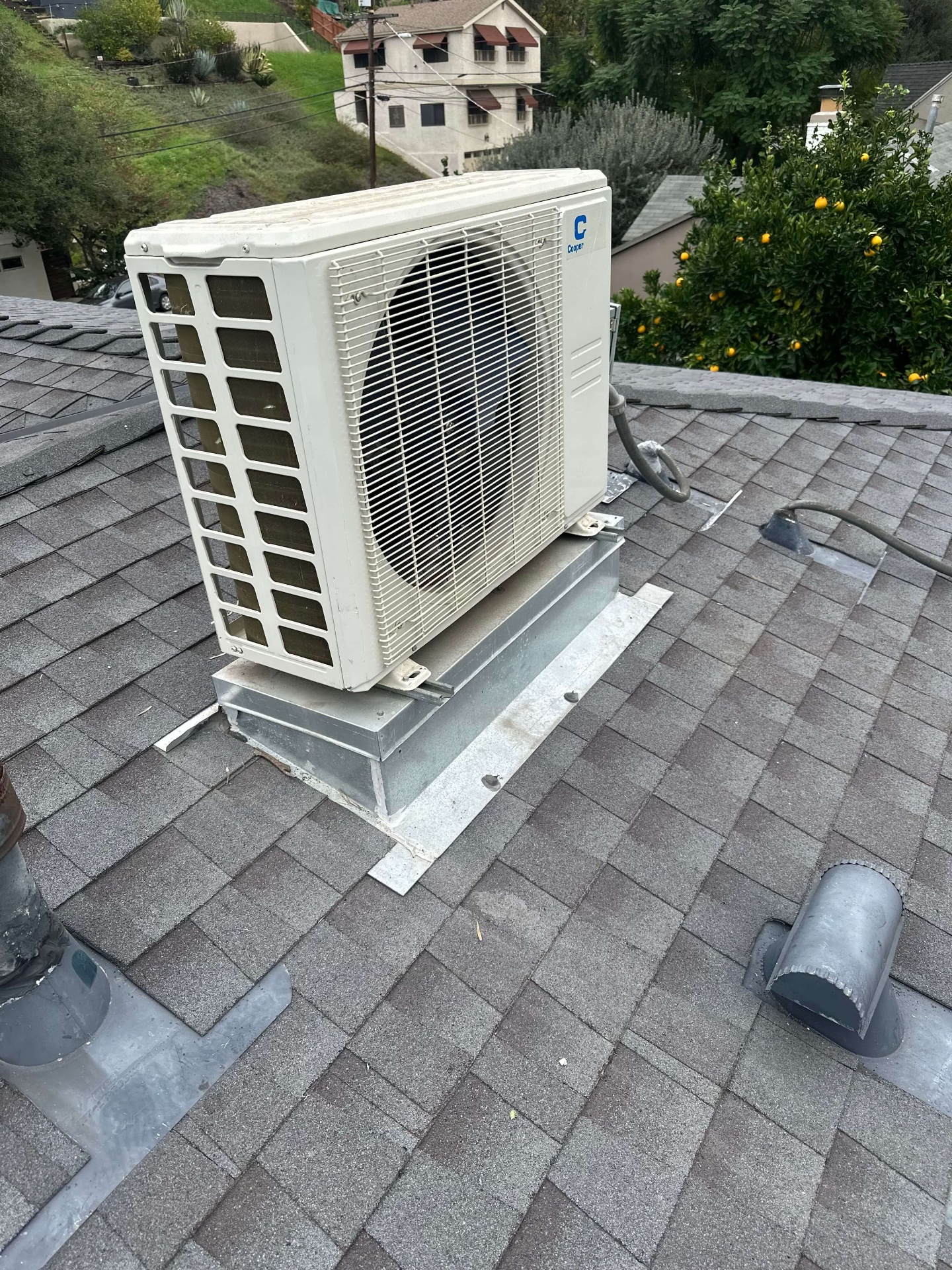 Cooper mini-split condenser installed on residential shingle roof